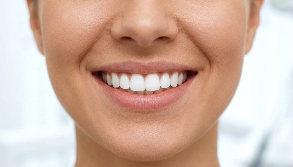 Close-up of a person's face with a bright smile showing white teeth.